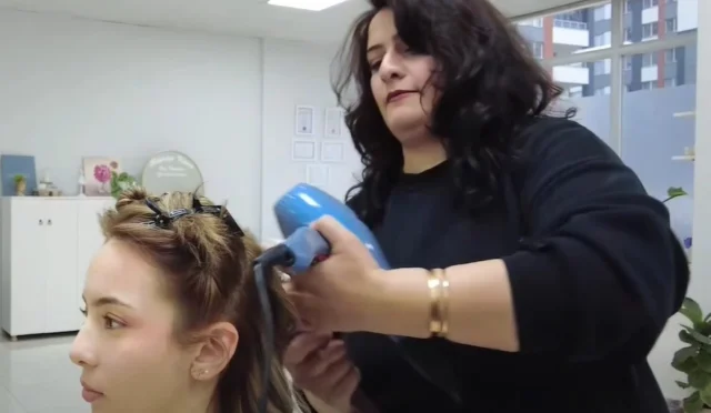 KAYMEK kursiyeri Hayriye Koca, kendi kuaför salonunu açtıktan sonra gülümserken