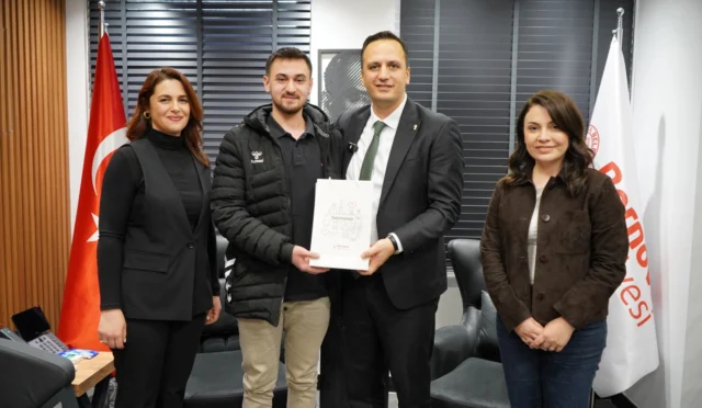 Bornova'da deneme sınavlarında dereceye giren öğrenciler, Belediye Başkanı Ömer Eşki ile hatıra fotoğrafı çektiriyor.