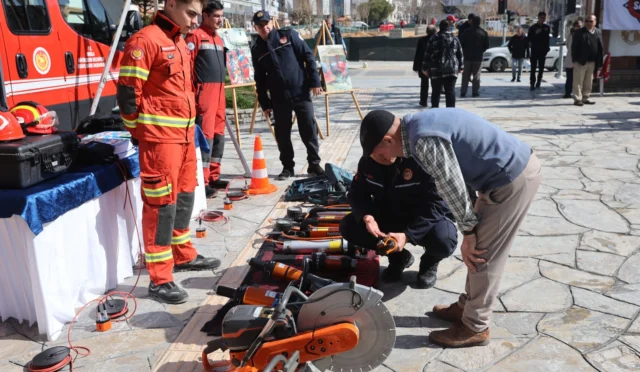 Muğla Menteşe'de düzenlenen Deprem Haftası etkinliğinde arama kurtarma ekipleri ve araçları sergileniyor, Başkan Ahmet Aras afetlere hazırlık mesajı veriyor.