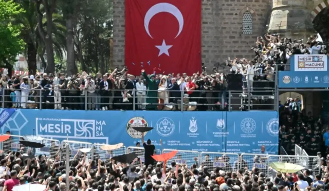 Manisa'da 486. Mesir Festivali'nde Sultan Camii kubbelerinden 10 ton mesir macunu halka saçılırken çekilmiş kalabalık ve coşkulu tören görüntüsü.