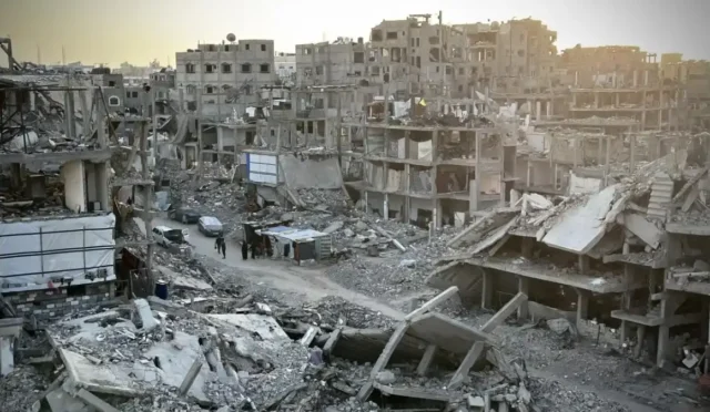 Gazze'de yıkım sonrası enkazlar arasında yürüyen insanlar