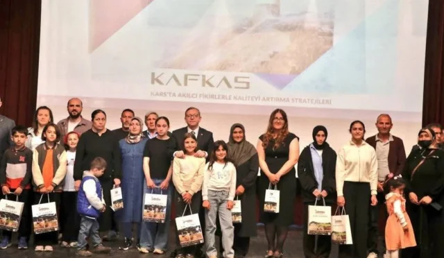 Kars'ta KAFKAS Projesi kapsamında düzenlenen ödül töreninde kitap okuyan öğrenciler ve veliler