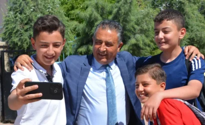 Kırıkkale Milli Eğitim Müdürü Rahmi Güney, öğrencilerle okul bahçesinde fotoğraf çektiriyor.
