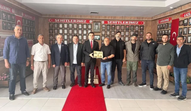 Kars Şehit ve Gaziler Derneği Başkanı Ağçay, Vali Yardımcısı Hayrettin Buğra Güzel'e teşekkür plaketi sunuyor.