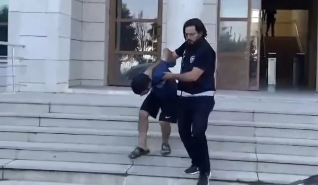Hatay'da eşini darbedip bıçakla tehdit eden koca polis tarafından gözaltına alındıktan sonra adliyeye sevk edilirken.