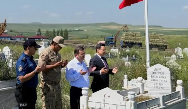 Kaymakam İsmail Demirtaş, 15 Temmuz şehitlerini anmak için şehitliğe karanfil bırakıyor.