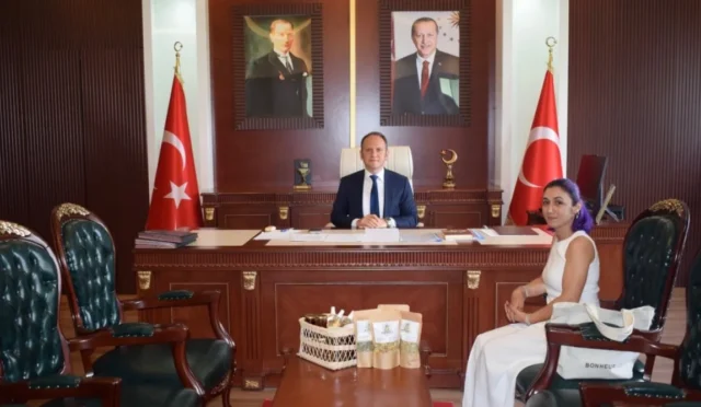 Mor saçlı çiftçi Bilsen Dağlı, yerel ürünleri hakkında bilgi vermek üzere Kırıkhan Kaymakamı Yunus Emre Akpınar'ı ziyaret ediyor.