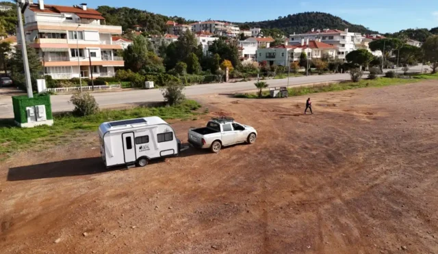 Ayvalık sahilinde park etmiş karavanlar ve uyarı levhası